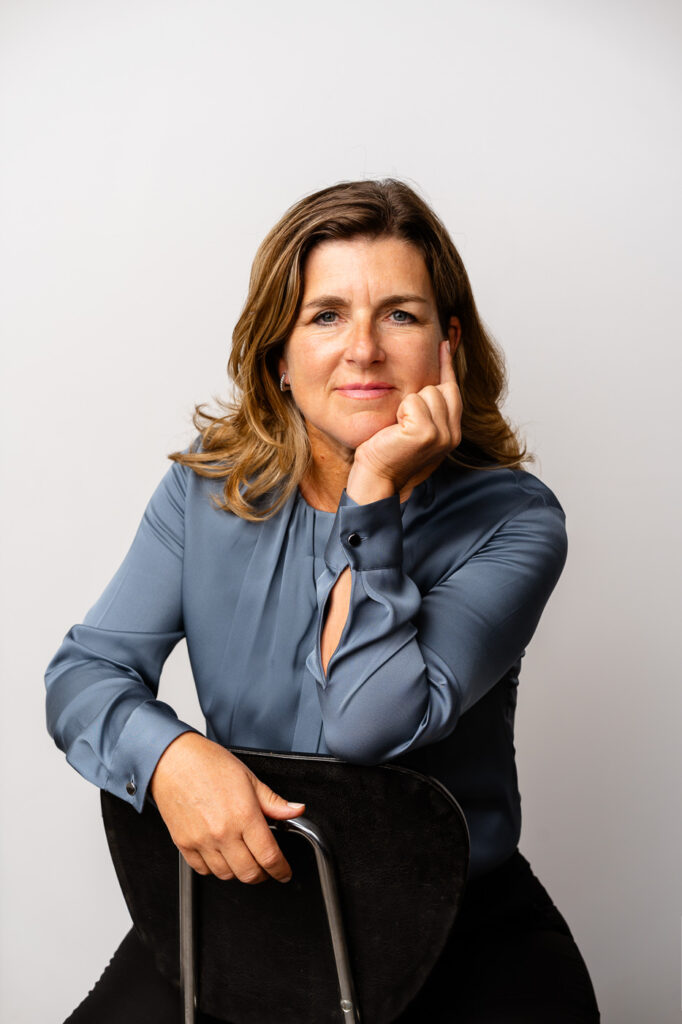 Bild von Melanie Schmidt-Krobok Geschäftsführerin von be-come one und Trainerin, Consultant und Coach auf eimen Stuhl sitzend und den Kopf auf eine Hand aufgestützt
